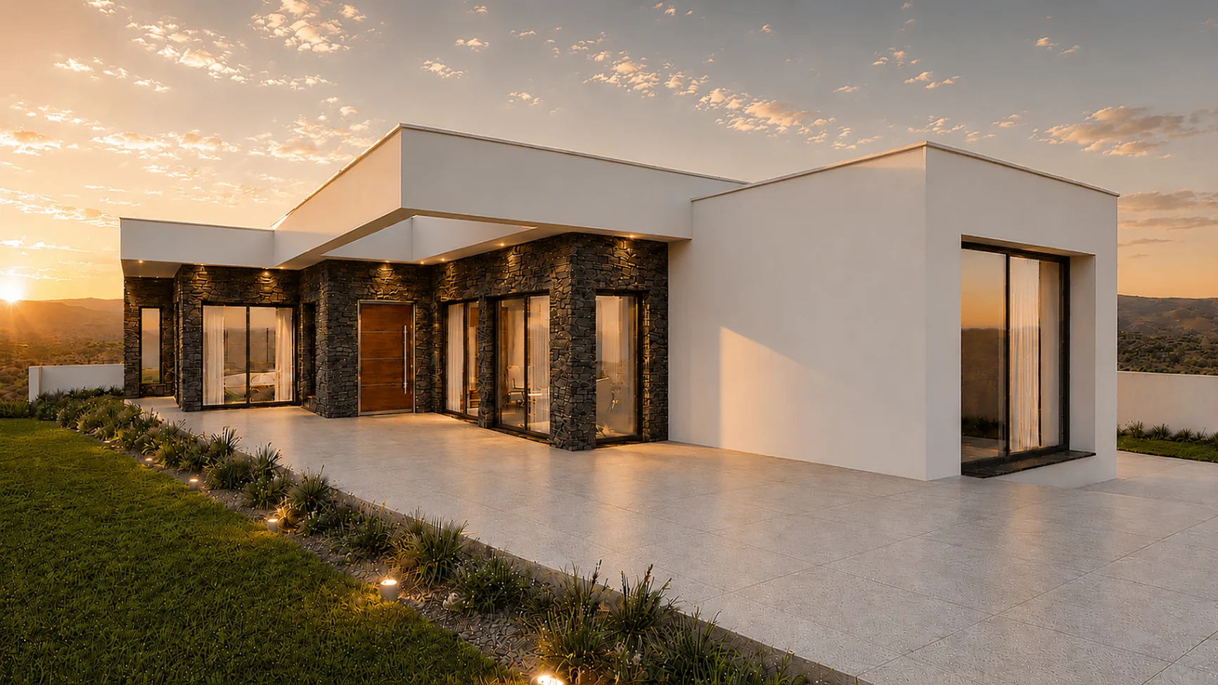 Casa São Bartolomeu, moradia unifamiliar térrea na Lourinhã ao pôr do sol, com volumes brancos, embasamento em pedra escura e grandes vãos envidraçados
